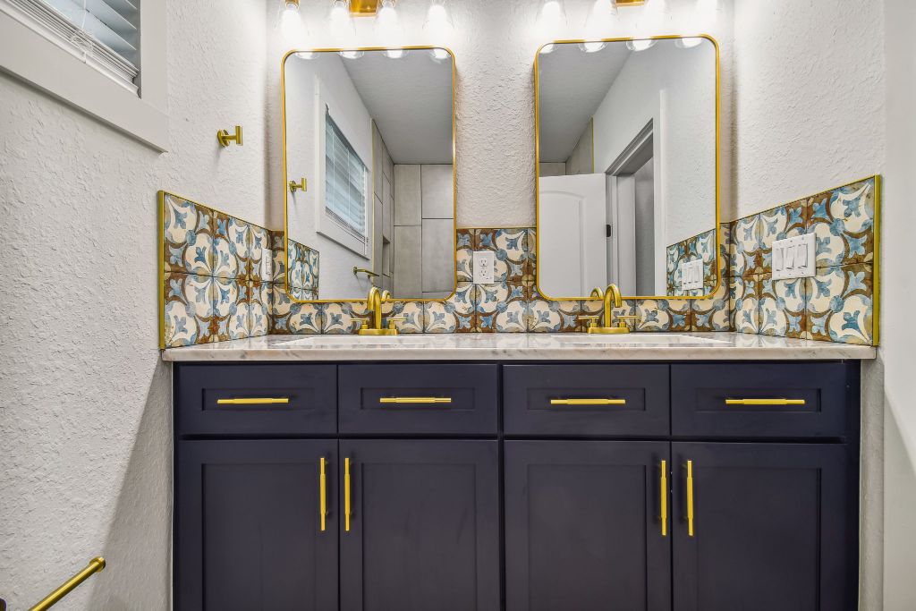 Investor flip interior design — Baker Ave navy vanity renovation by Davison Refined Design