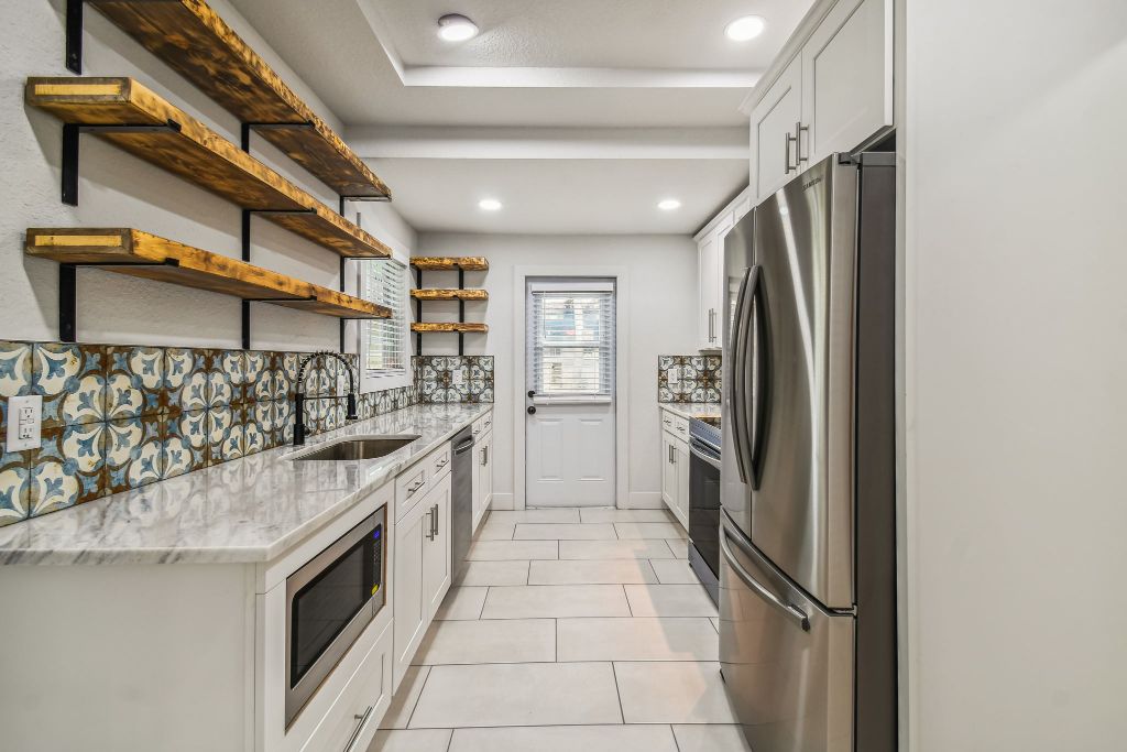 Baker Ave kitchen after — encaustic tile, open wood shelves, marble counters